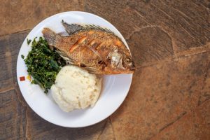 Traditional african food - ugali, fish and greens